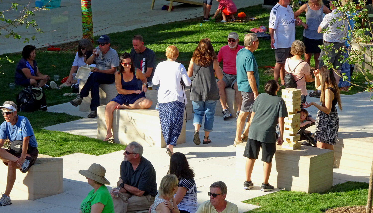 People sit on stone stone slab seats within the stone path.