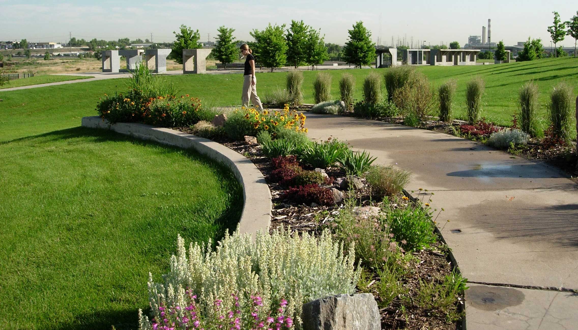 A photo shows a semi-circular garden between concrete bands leftover from the previous use on the site.