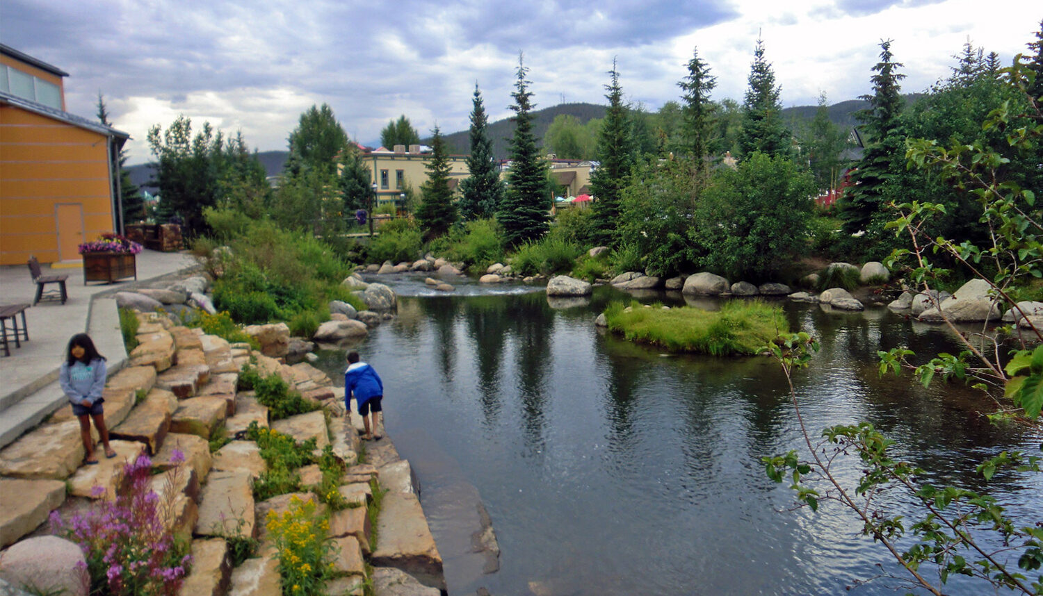 Children explore the stone slab tiers that lead down to deep pools of the river.