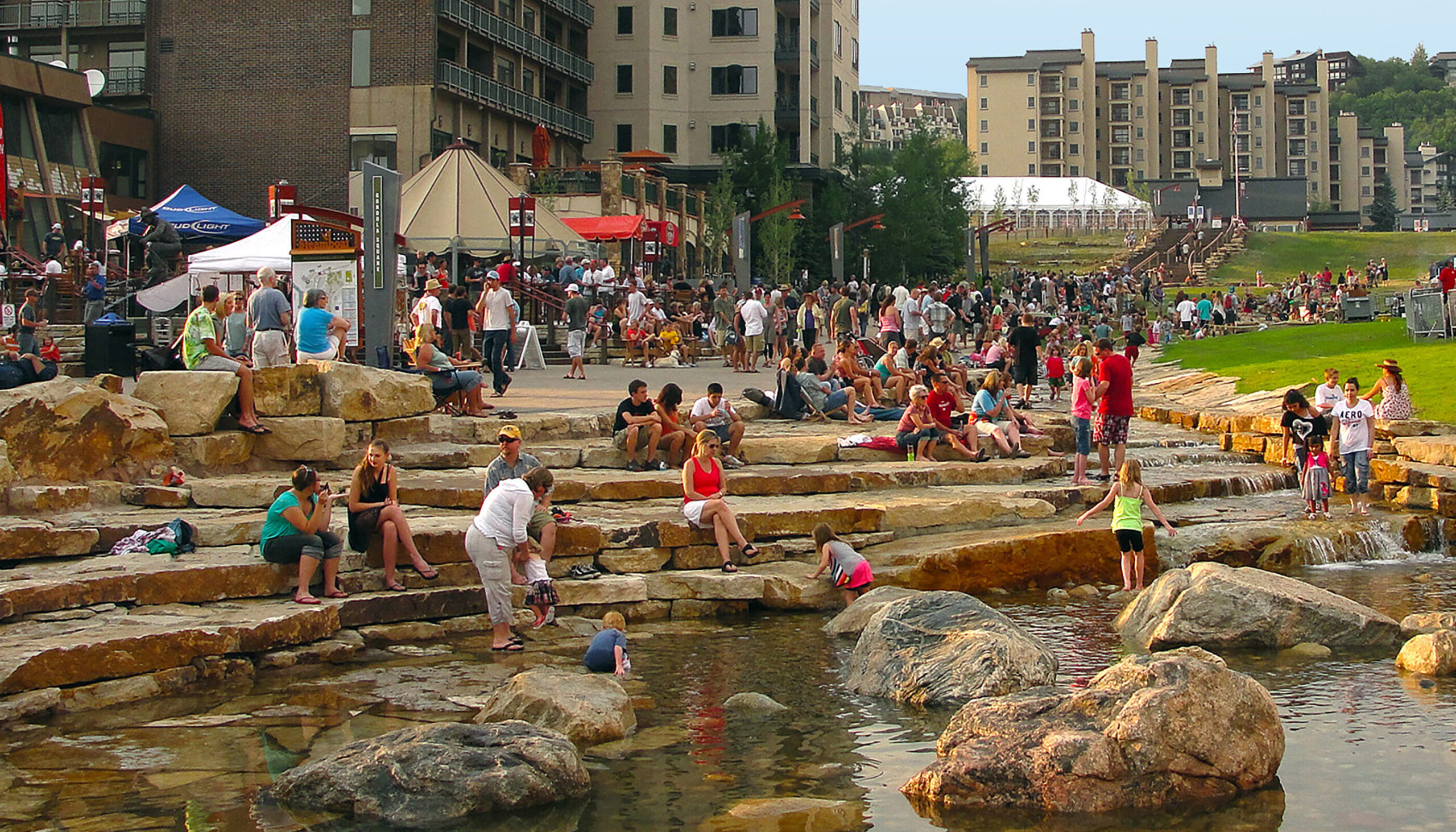community-filled promenade and along the stone edge of Burgess Creek in the late afternoon