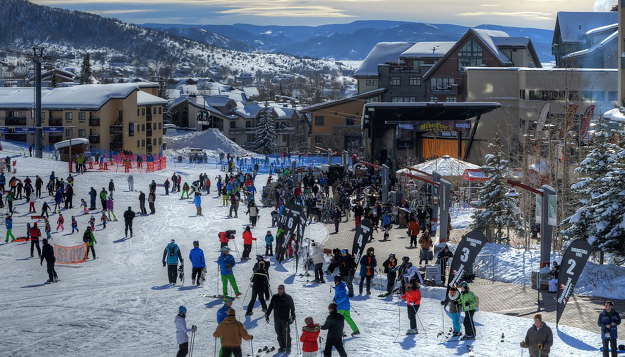 bird's eye winter view of the promenade, skiers glide over the snow to the paved promenade edge