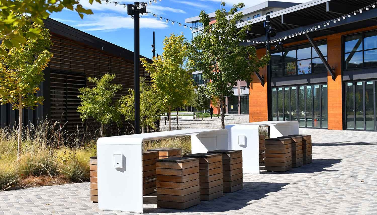 Tables with wifi and wood seats sit adjacent to the pavilion with twinkle lights dangling overhead.